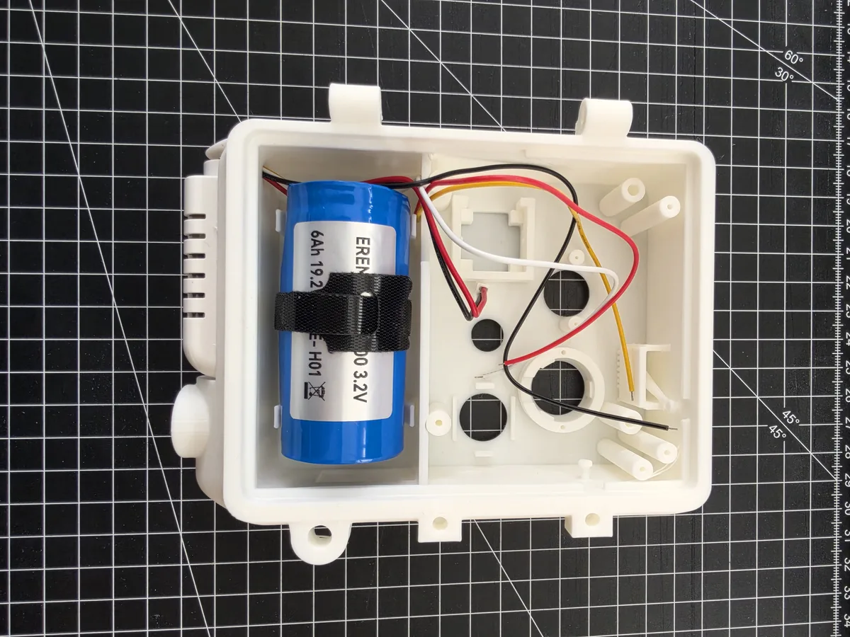 Housing with an inserted battery held in place by a Velcro strap