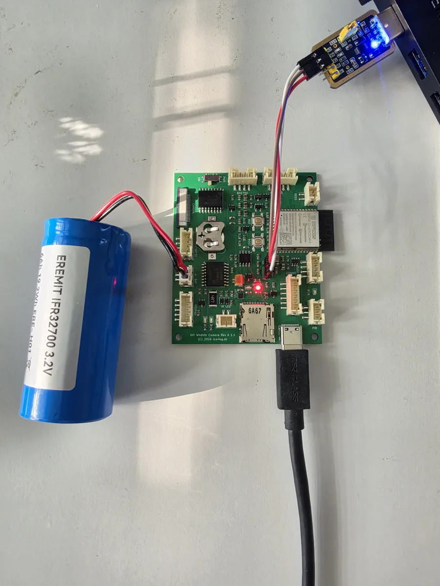Trail camera PCB in operation with connected battery and serial adapter